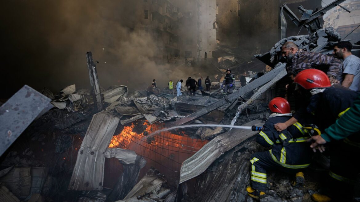 Firefighters try to put out flames at the site of an Israeli airstrike that struck an apartment building in Beirut, Lebanon, Wednesday. (AP Photo)