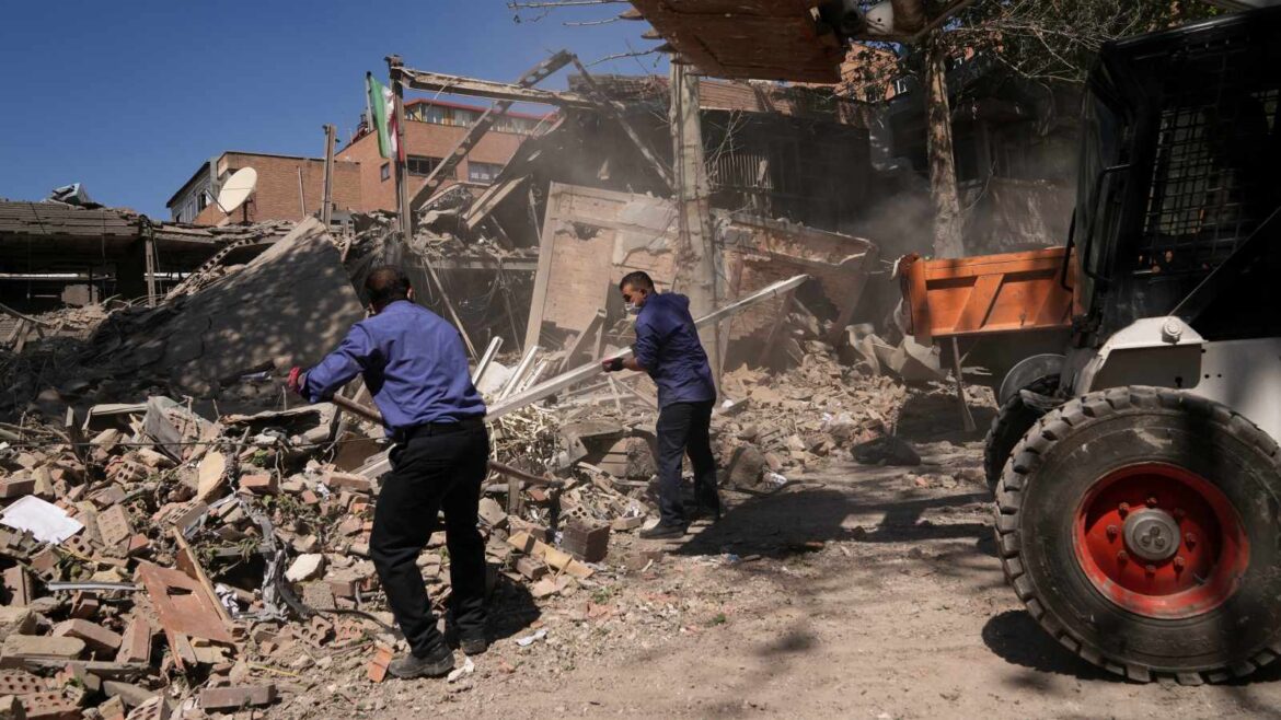 Workers remove debris at Tehran's Sharif University of Technology complex that Iranian authorities say was hit by a US.-Israeli strike, in Tehran (AP Photo)